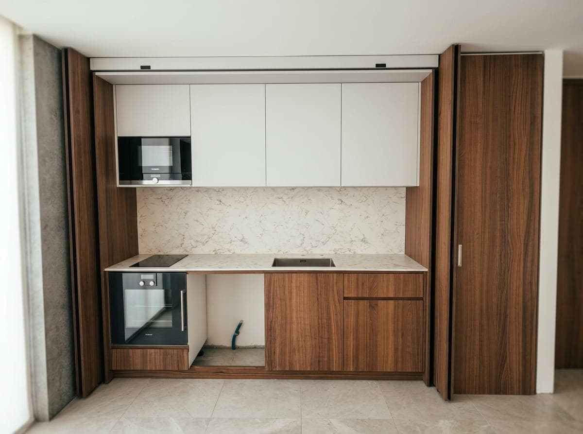 Cuisine compacte — placage noyer massif et crédence pierre claire